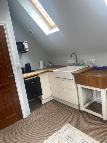 a small kitchen with a sink and a window at The Willows Lovely Double Apartment in Rostrevor
