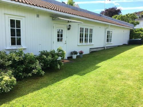 una casa blanca con un patio delante en Koselig maritim leilighet sentralt i Stavern, en Stavern