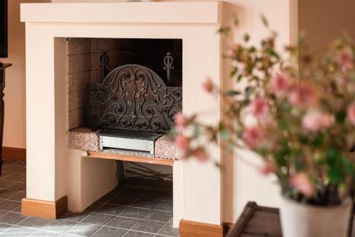 a fireplace in a room with flowers in the foreground at Residenza Santa Cecilia in San Vincenzo