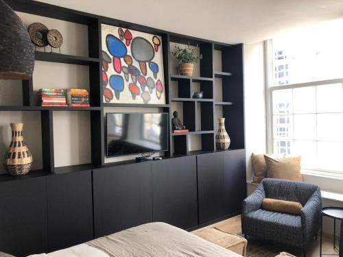 a bedroom with a black wall with a tv and a chair at Hartje Goes! in Goes
