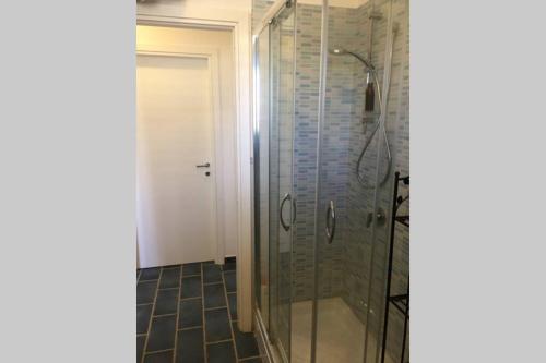 y baño con ducha y puerta de cristal. en Vacanze isolane en Favignana