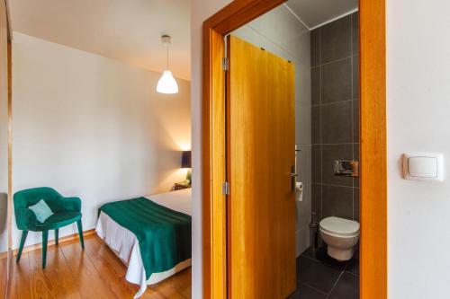 a bedroom with a bed and a bathroom with a toilet at Oporto City View - São Lázaro in Porto