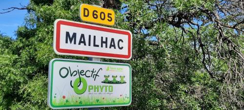 two street signs on a pole in front of trees at Le Coq du Nord - Mailhac Gîte et Chambres d'Hôtes in Mailhac