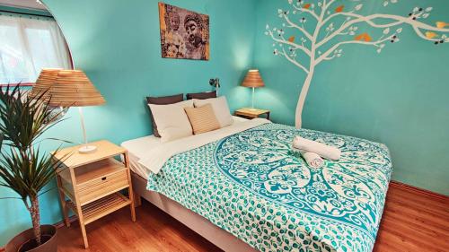a bedroom with a bed with a tree mural on the wall at Shantee House in Budapest