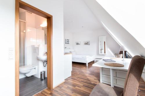 een witte badkamer met een wastafel en een toilet bij fewo1846 - Strandresidenz Wassersleben Lee - strandnahes Studioapartment im Dachgeschoss in Harrislee