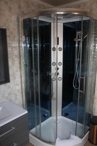 a shower with a glass enclosure in a bathroom at Vicuña Lodge in San Pedro de Atacama