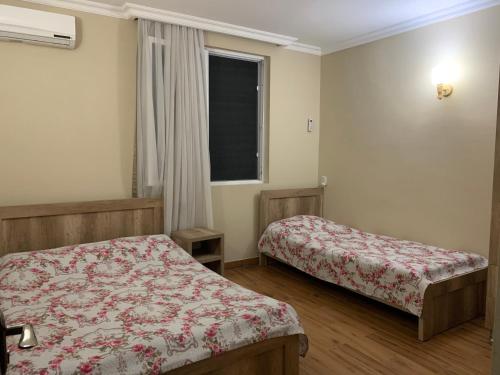Un dormitorio con dos camas y una ventana. en Tamari, en Ureki
