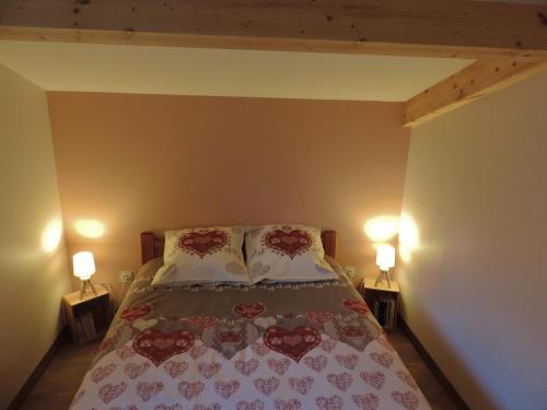 une chambre avec un lit avec deux oreillers et deux lampes dans l'établissement Le Nidouyé appartement 2 adultes UNIQUEMENT à Saint Lary Soulan, à Saint-Lary-Soulan
