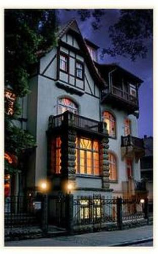 a large white house with illuminated windows at night at Sax Imperial in Dresden