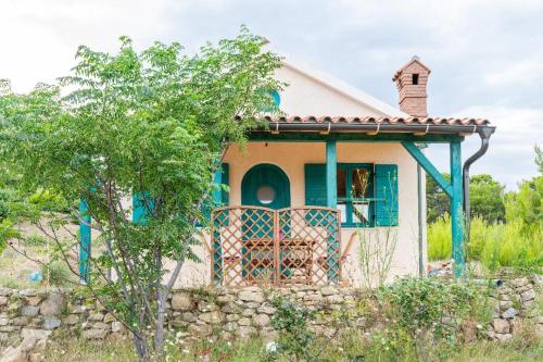 una piccola casa con un muro di pietra di Arya House a Lopar