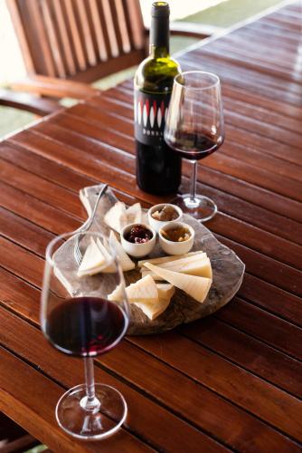 a table with two glasses of wine and a plate of cheese at Agriturismo Podere L'Agave in San Vincenzo