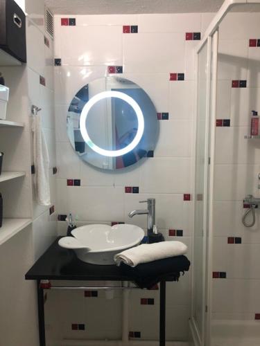 une salle de bain avec un lavabo et un miroir dans l'établissement Cap d'Agde - Résidence Estivales - proche naturiste - Terrasse - Wifi - Parking - Piscine - Clim, au Cap d'Agde