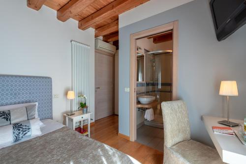 a bedroom with a bed and a bathroom at Hotel Rovere in Treviso