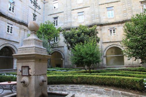 a building with a fountain in front of a courtyard at Hospedería San Martín Pinario in Santiago de Compostela