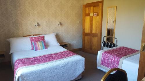 ein Hotelzimmer mit 2 Betten und einer Tür in der Unterkunft Riverwalk House B&B in Oughterard