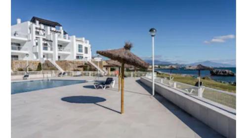 ein Resort mit einem Pool und einem Sonnenschirm in der Unterkunft Casares del Mar Luxury Apartment in Málaga