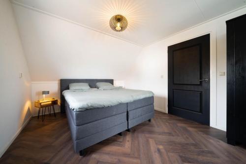 - une chambre avec un lit et une porte noire dans l'établissement Dierenweide Upstairs, à Goedereede