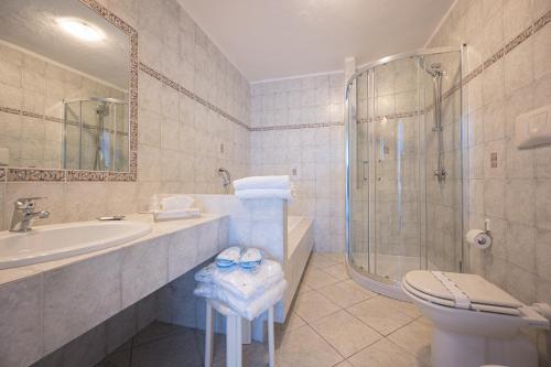 a bathroom with a shower and a toilet and a sink at Grand Hotel Le Rocce in Gaeta