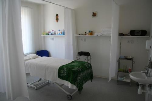 ein Krankenhauszimmer mit einem Bett und einem Waschbecken in der Unterkunft Lazensky Hotel Park in Poděbrady
