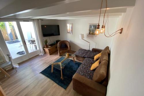 uma sala de estar com um sofá e uma televisão em Tiny House - town house in the centre of Annecy terrace & air conditioning em Annecy