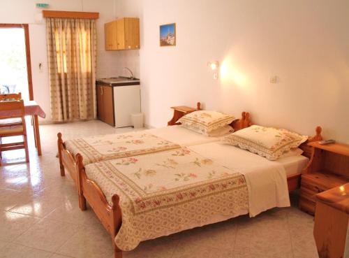 a bedroom with two twin beds and a kitchen at Scarpantos in Amoopi
