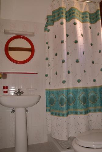 ein Badezimmer mit Waschbecken und Duschvorhang in der Unterkunft Scarpantos in Amoopi