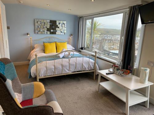 a bedroom with a bed and a large window at The Watermark in Looe