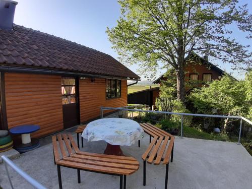 un patio con 2 sillas, una mesa y una casa en Kuća za odmor ANAMARIJA, en Ogulin