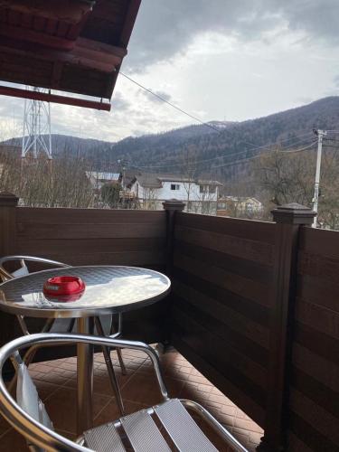 un patio con tavolo e sedie sul balcone. di vila Monski ad Azuga