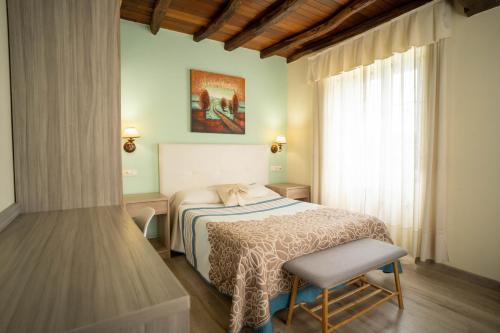 1 dormitorio con 1 cama, 1 silla y 1 ventana en El Pinar en Ribadeo
