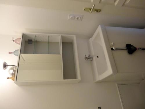Armario blanco con espejo en el baño en Le Petit Marais, en Isigny-sur-Mer