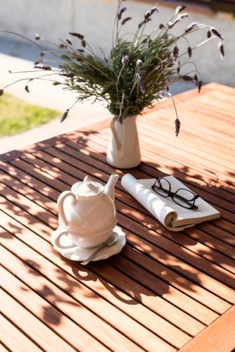 a table with a tea pot and a vase with a plant at Agriturismo Podere L'Agave in San Vincenzo