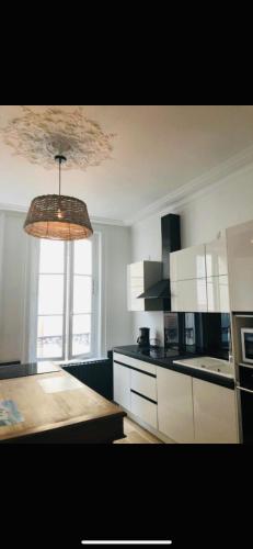 une cuisine avec des armoires blanches et un meuble lumineux dans l'établissement SON DES MOUETTES PLAGE, à Trouville-sur-Mer