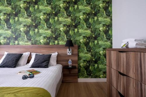 a bedroom with a bed with a green wallpaper at ATHOME RESIDENCE ET SPA in La Rochelle