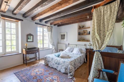 1 dormitorio con 1 cama, escritorio y ventanas en Maison d'hôtes Moulin du Bas Pesé, en Mont-près-Chambord