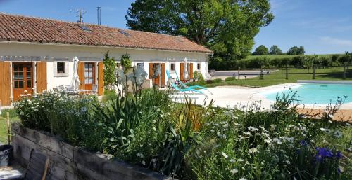 a house with a garden with a swimming pool at La Vieille Gorce Gîtes in the Vienne in Asnois