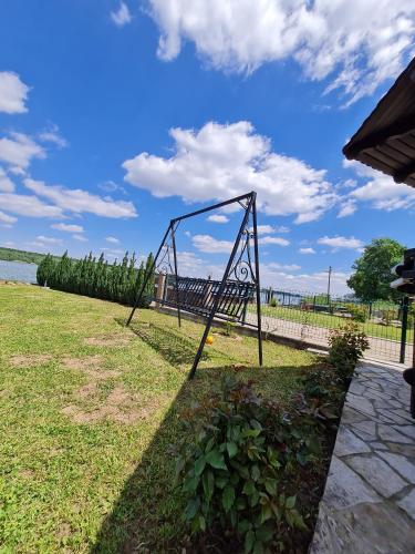 a swing set on the grass near the water at San na vodi in Smederevo