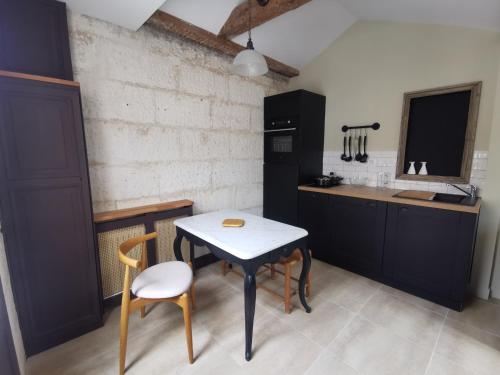 uma cozinha com uma mesa e cadeiras e um lavatório em Appartement Escapade Marine - Maison d Aligre em Marans