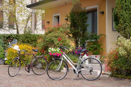 two bikes parked in front of a house with flowers at Hotel Rovere in Treviso