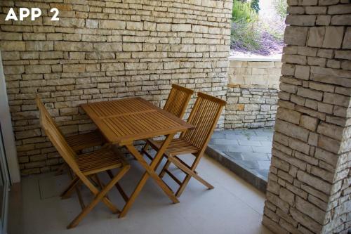 a wooden table and chairs sitting next to a brick wall at Casa Maly in Portorož
