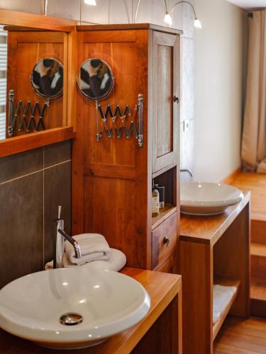 a bathroom with a sink and two mirrors at Domaine de la Pommeraye & Spa in La Pommeraye