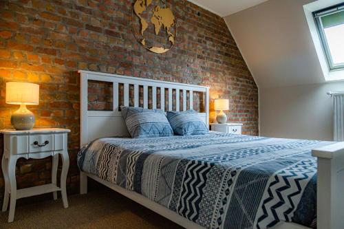 a bedroom with a bed and a brick wall at Suite Leopold in Bruges