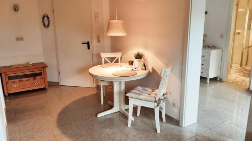 uma cozinha com uma mesa e duas cadeiras e uma mesa em Fewo Bernhardt " App. 2 " em Scharbeutz