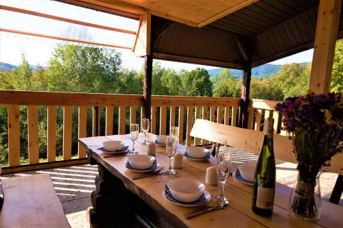 un tavolo con bicchieri e una bottiglia di vino su un ponte di Rudera u Sióstr DREWNIANY DOMEK Stróża a Stróża