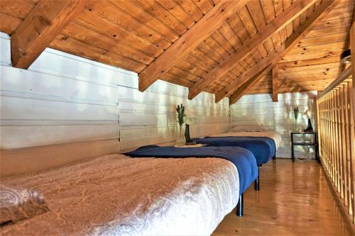 una fila di letti in una camera con soffitti in legno di Rudera u Sióstr DREWNIANY DOMEK Stróża a Stróża