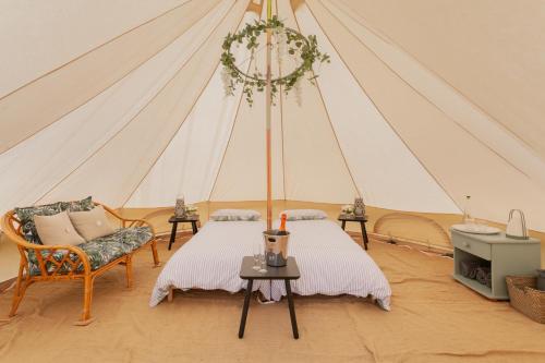 um quarto com uma tenda com uma cama e uma mesa em Duneden Belle Glamping em Randalstown