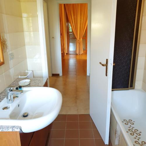 a bathroom with a white sink and a tub at Hotel Paradiso Dépendance in Altedo