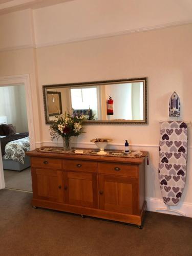 a bathroom with a wooden dresser with a mirror at Milton Lodge in Weston-super-Mare