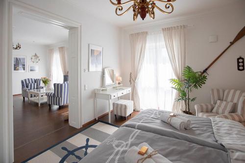 a bedroom with a bed and a desk and chairs at Captain's Suite in Neusiedl am See