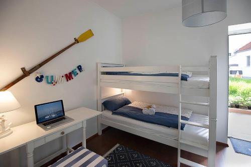 a bedroom with bunk beds and a desk with a laptop at Captain's Suite in Neusiedl am See